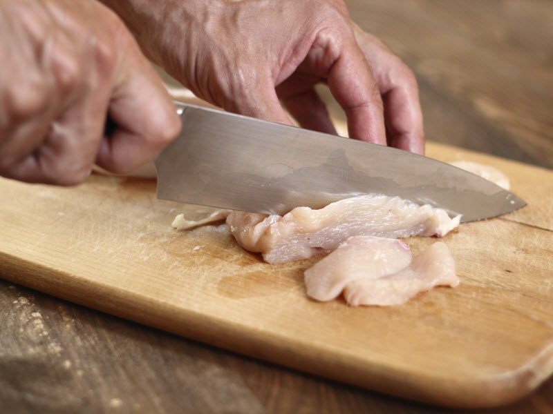 Consumer prepare raw chicken for a meal at home