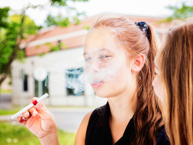 Teenager vaping an e-cigarette