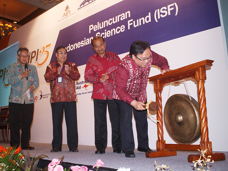An official rings a gong at the launch of the Indonesian Science Fund.
