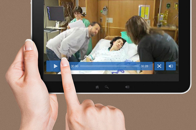 A tablet displays a screen capture from a training video produced by RTI in support of the Safety Program for Perinatal Care developed on behalf of the U.S. Agency for Healthcare Research and Quality